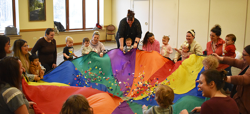 children and parents enjoying parachute play